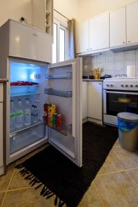 a kitchen with an open refrigerator with drinks in it at Eleni House in Didyma