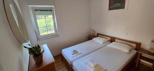 a small bedroom with a bed and a window at Apartments Villa Andreja in Starigrad
