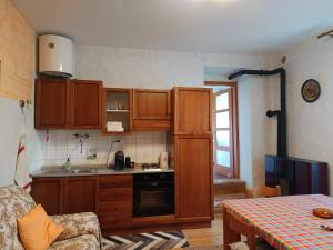 a small kitchen with wooden cabinets and a table at Il Pellicano in Rovereto