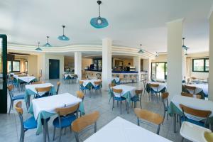a dining room filled with tables and chairs at Santa Marina Hotel in Agios Nikitas