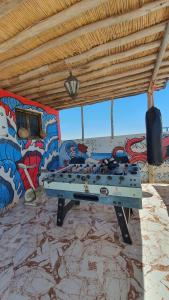 a ping pong table in a room with graffiti at Azour House in Taghazout