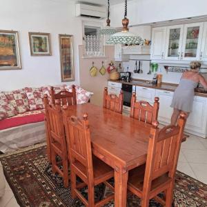 een vrouw in een keuken met een houten tafel bij Apartment Indira in Vela Luka