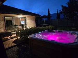 d'un bain à remous avec éclairage rose dans la cour. dans l'établissement Forest Lakes Luxury, à Rotorua 50 autres photos
