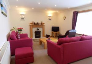 a living room with purple furniture and a fireplace at Bosta 12 Knock in Stornoway