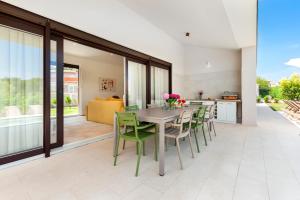 a kitchen and dining room with a table and chairs at Echo villa, Istra, pool/jacuzzi, BBQ, pet friendly in Šegotići