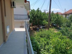 a balcony of a house with trees and bushes at Xrisa Apartments in Petalidi +3 photos
