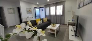 salon z kanapą i stołem w obiekcie Moderno apartamento frente al mar w Puerto de la Cruz