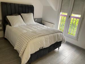 a bedroom with a large bed with a black headboard at HSH France Chambre City 6 Proche de Disney in Meaux