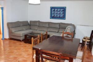 a living room with a couch and a table and chairs at El cortijo azul in Güéjar-Sierra