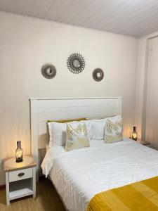 a bedroom with a white bed with two mirrors on the wall at Wanansha Apartments in Gaborone +3 photos