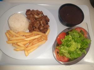 a plate of food with french fries and rice at Apartamento Brisa 201 in Pedra de Guaratiba