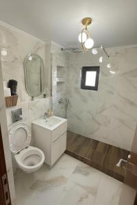 a bathroom with a toilet and a sink and a mirror at Luxury Stay in Brăila