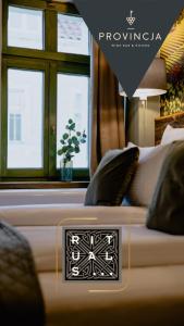 a bedroom with a bed with pillows and a window at Boutique Provincja Winebar & Rooms in Olsztyn
