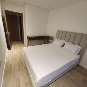 a large white bed in a bedroom with a wooden floor at Diana Ennour in Rabat