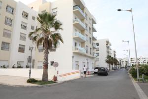 a palm tree on a street next to a building at Diana Ennour in Rabat