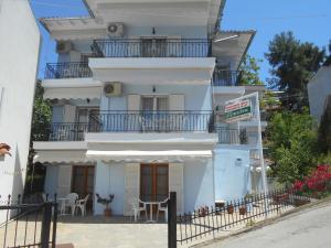 a white building with a table and chairs in front of it at Villa Hermione in Agia Paraskevi