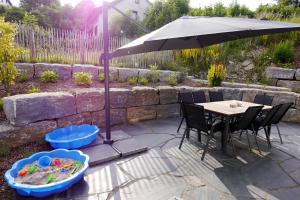 a patio with an umbrella and a table and chairs at First Class Domizil Großer Bergzauber inklusive MeineCardPlus in Willingen +37 photos