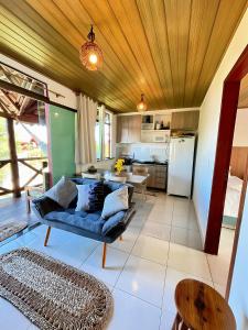 a living room with a blue couch and a kitchen at Casa de Praia Chalé Luís Correia Piauí in Luis Correia
