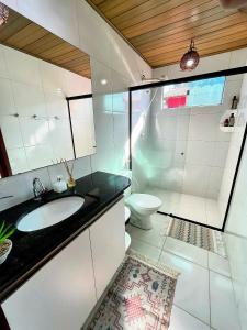 a white bathroom with a sink and a toilet at Casa de Praia Chalé Luís Correia Piauí in Luis Correia