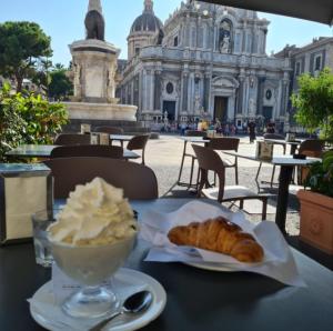 a table with a bowl of whipped cream and a pastry at Asmundo Palace Suites & Spa in Catania