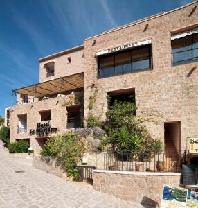 een bakstenen gebouw met ramen aan de zijkant bij Hôtel & Restaurant Le Belvédère in Porto Ota