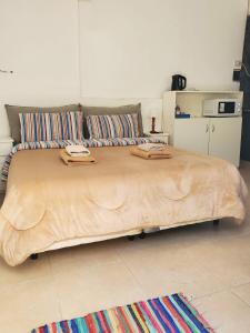 Cama grande de madera en habitación con cocina en Casa de Invitados 2, en Pergamino 2 fotos más