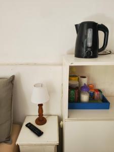 Una lámpara en una mesa junto a una cafetera en un estante. en Casa de Invitados 2, en Pergamino