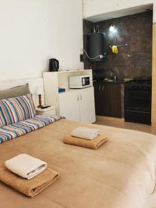 Una cocina con un sofá y dos toallas en el suelo. en Casa de Invitados 2, en Pergamino