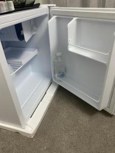 an open refrigerator with a bottle of water in it at Sammy's guest house in Prescot +32 photos