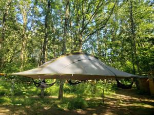 a tent sitting in the middle of a forest at Tentes suspendues D'En Haut in Friaudour