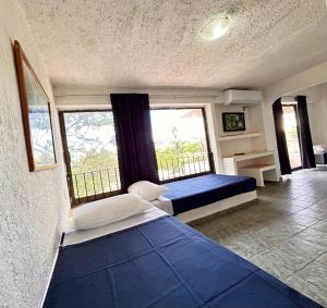 een slaapkamer met twee bedden en een groot raam bij Íkaro Suites Cancún in Cancun