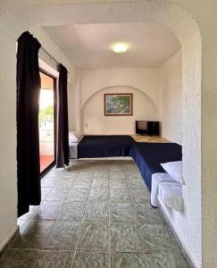 een kamer met een bed, een televisie en een raam bij Íkaro Suites Cancún in Cancun