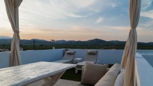 a balcony with a table and chairs and a view at Evnia Sunset Crete Escape, Private HotTub Retreat in Rotásion