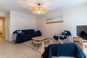 a living room with a blue couch and a table at Proche mer très agréable appt de 2 ch pour 5 pers garage en ss in Le Touquet-Paris-Plage