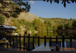 a view of a lake with tables and chairs at Anna grandmas house in Zarós
