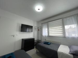 a bedroom with a bed and a flat screen tv at Studios Lora RM 860 in Saint-Louis