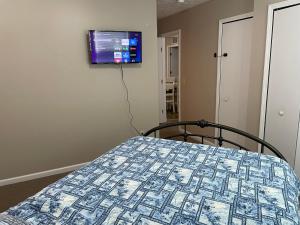 a bedroom with a bed and a tv on the wall at Lazy Days Geneva On The Lake in Geneva