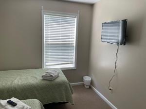 a bedroom with a bed and a television on the wall at Lazy Days Geneva On The Lake in Geneva