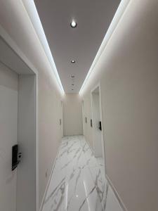 a hallway with white walls and white marble floors at Azure Waves in Vlorë