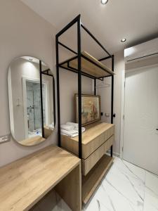 a bathroom with a large mirror and wooden shelves at Azure Waves in Vlorë