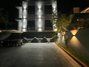 a building with chairs in front of a building at night at Azure Waves in Vlorë