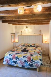 a bedroom with a bed with a colorful comforter at Deux appartements - Gîte aux 1000 chemins in Saint-Joseph-de-Rivière
