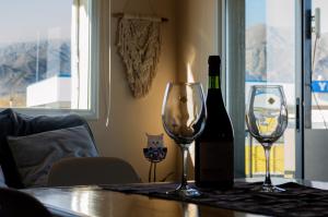 a bottle of wine and two wine glasses on a table at departamento la punta in La Punta
