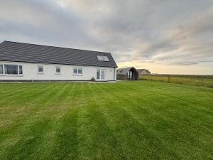 a white house with a large grass field at Sea Breeze - Sea Scape View in Keiss