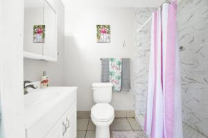 baño con aseo blanco y cortina de ducha rosa en Luxe Pool Casita w Saltwater Pool 25 Min to PCB, en Panama City