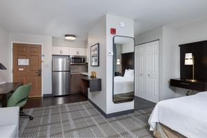 a hotel room with a bed and a kitchen at Staybridge Suites Madison - East by IHG in Madison