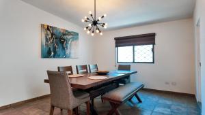 a dining room with a table and chairs and a chandelier at White House Cabo in Cabo San Lucas