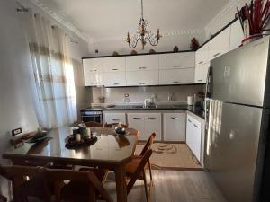a kitchen with a table and a refrigerator at Klarisa Beach Apartment in Golem