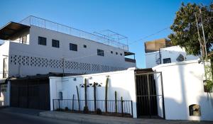 a white building with a fence in front of it at White House Cabo in Cabo San Lucas