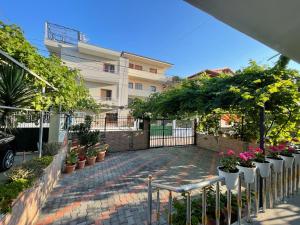 a brick walkway with potted plants and a building at Klarisa Beach Apartment in Golem +4 photos